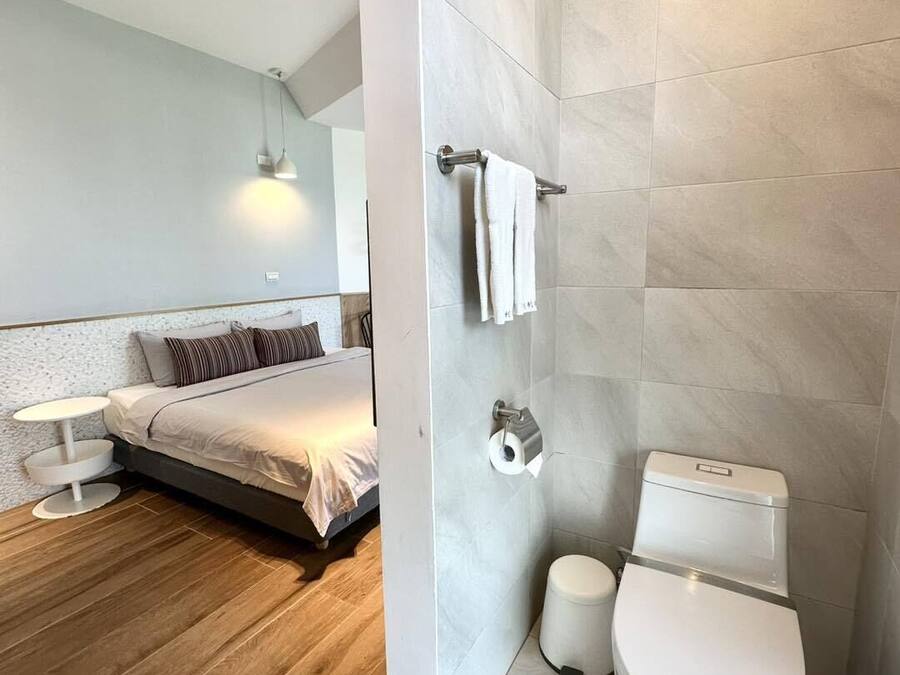 A modern bathroom with a toilet, bidet, and towel rack.