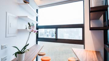 Una cocina moderna con encimera de madera, taburetes naranja y ventilador de techo.