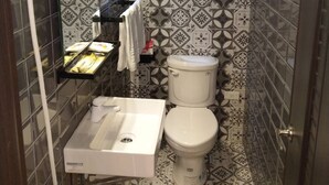 Une salle de bain avec des toilettes, un lavabo et une douche.