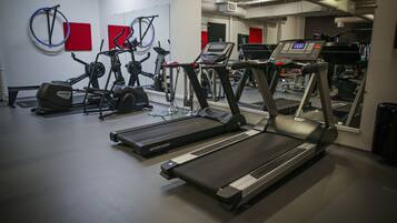 A gym with treadmills, stationary bikes, and elliptical machines.