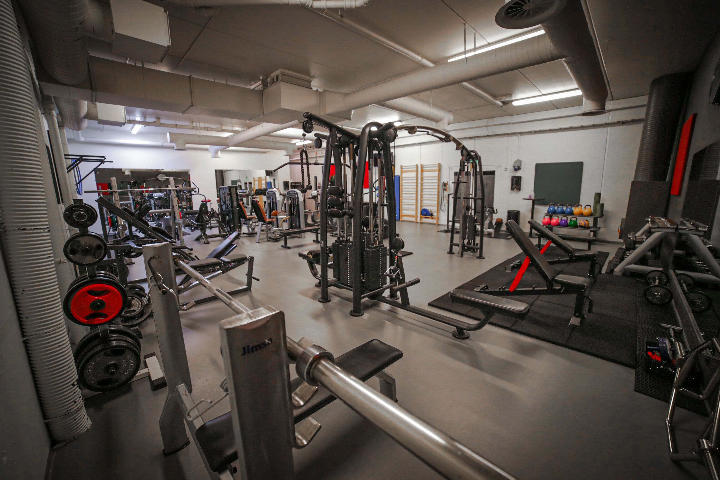 A gym with various exercise equipment, including weight machines and free weights.