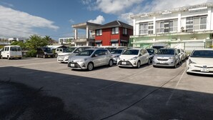 Een parkeerplaats met diverse auto's en een gebouw op de achtergrond.