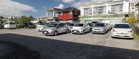 A parking lot with several cars and a building in the background.