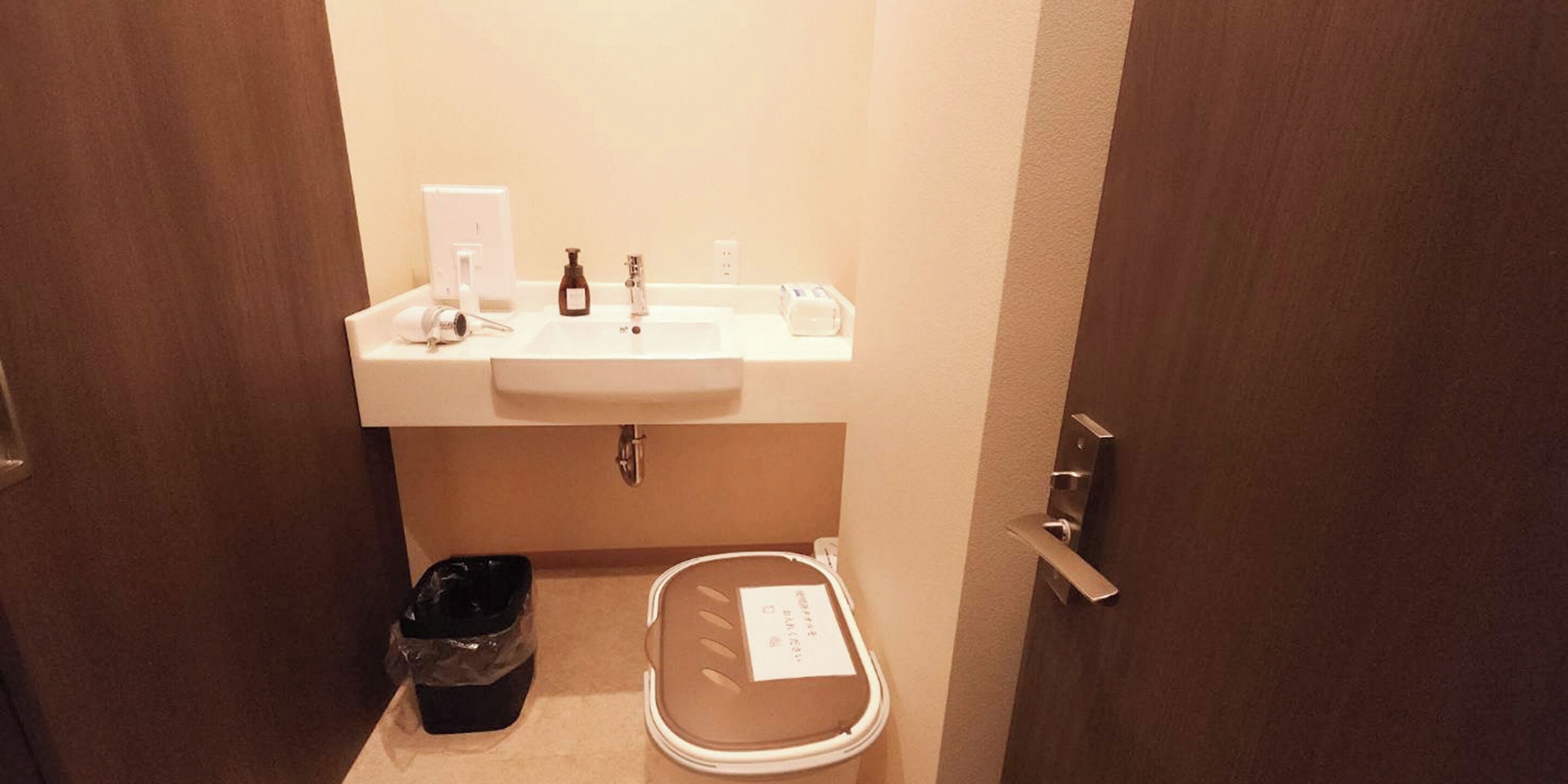 A small bathroom with a sink, a trash bin, and a toilet.