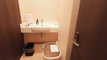 A small bathroom with a sink, a trash bin, and a toilet.