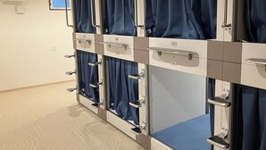Een rij privékamers met individuele gordijnen en metalen handgrepen.