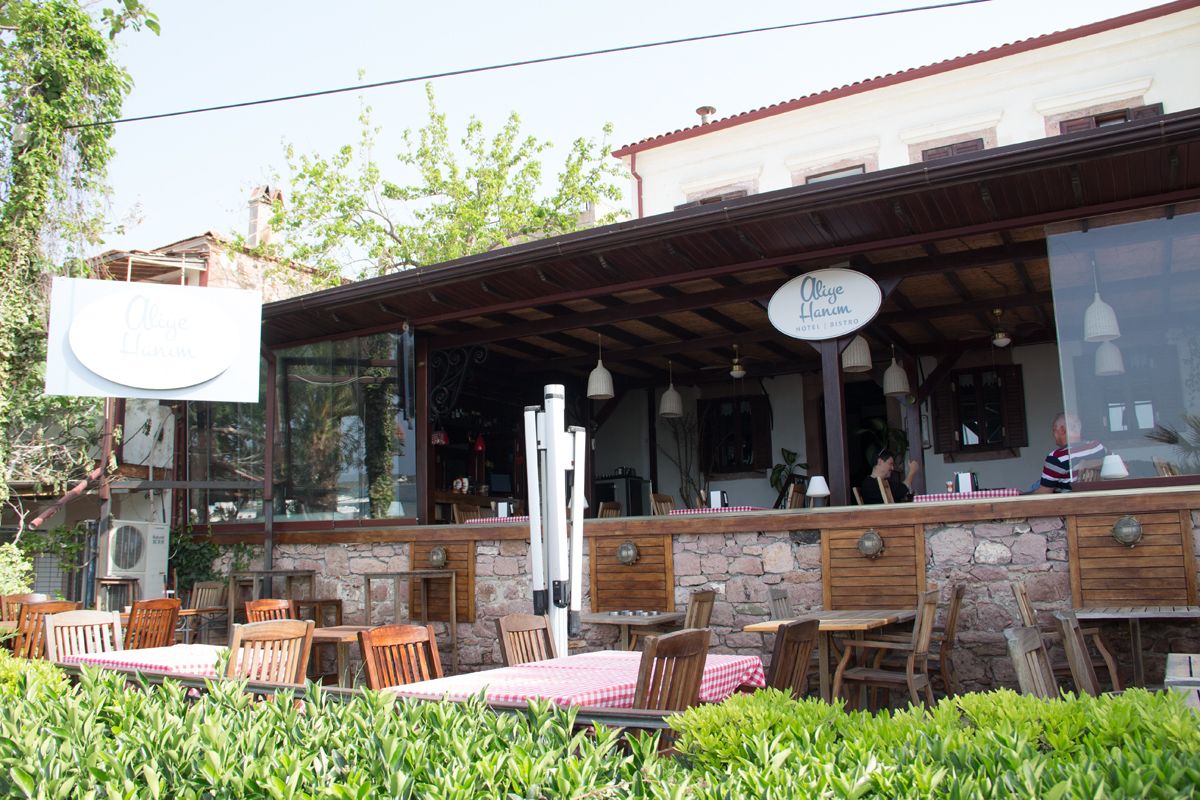 Um café ao ar livre com paredes de pedra e móveis de madeira.