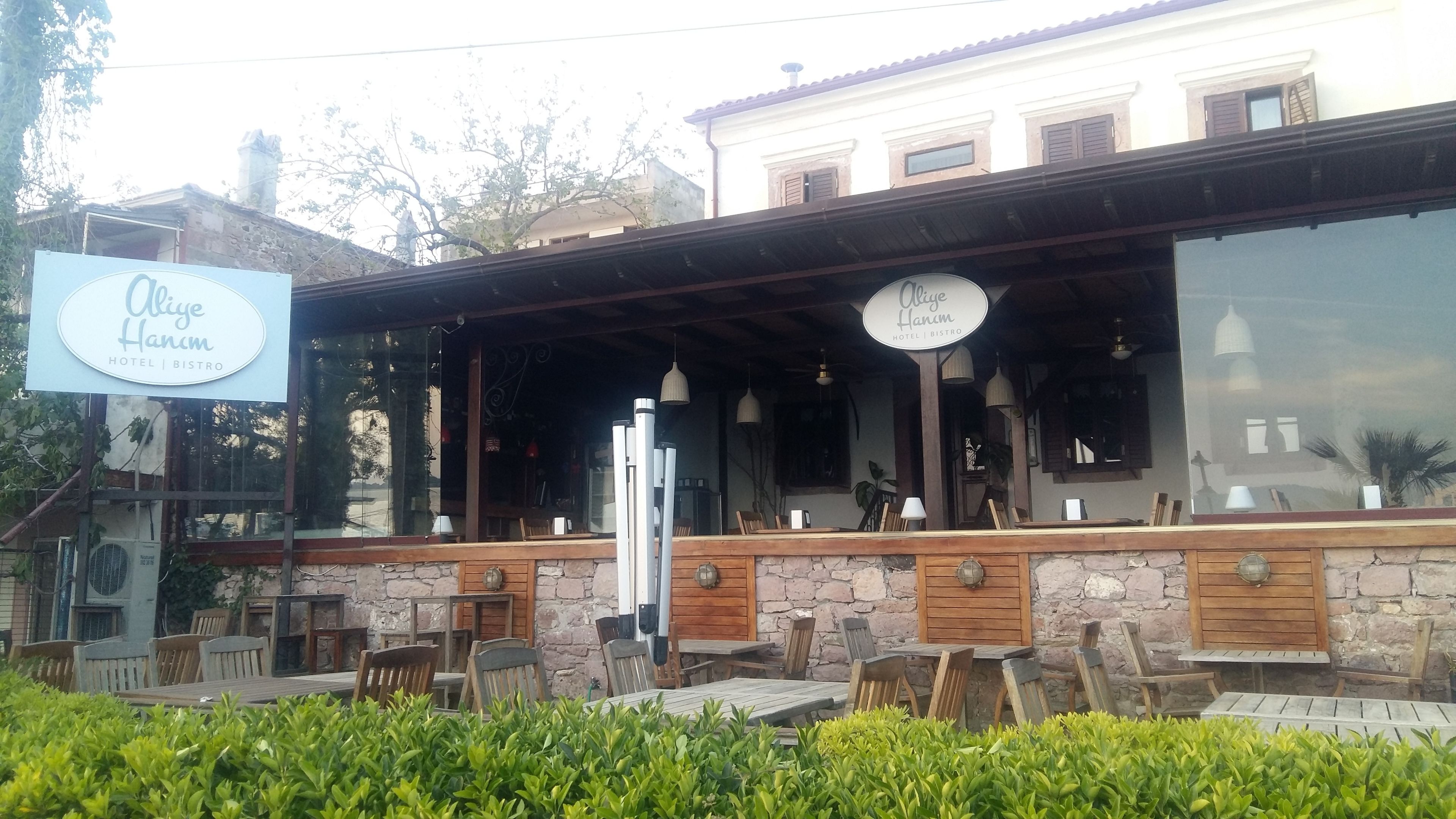 A hotel with outdoor seating and a stone facade.