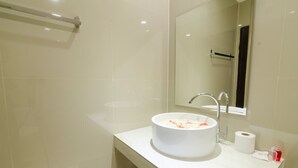 A modern bathroom with a white sink, a mirror, and a towel rack. - My Living Place Nathon (Koh Samui)