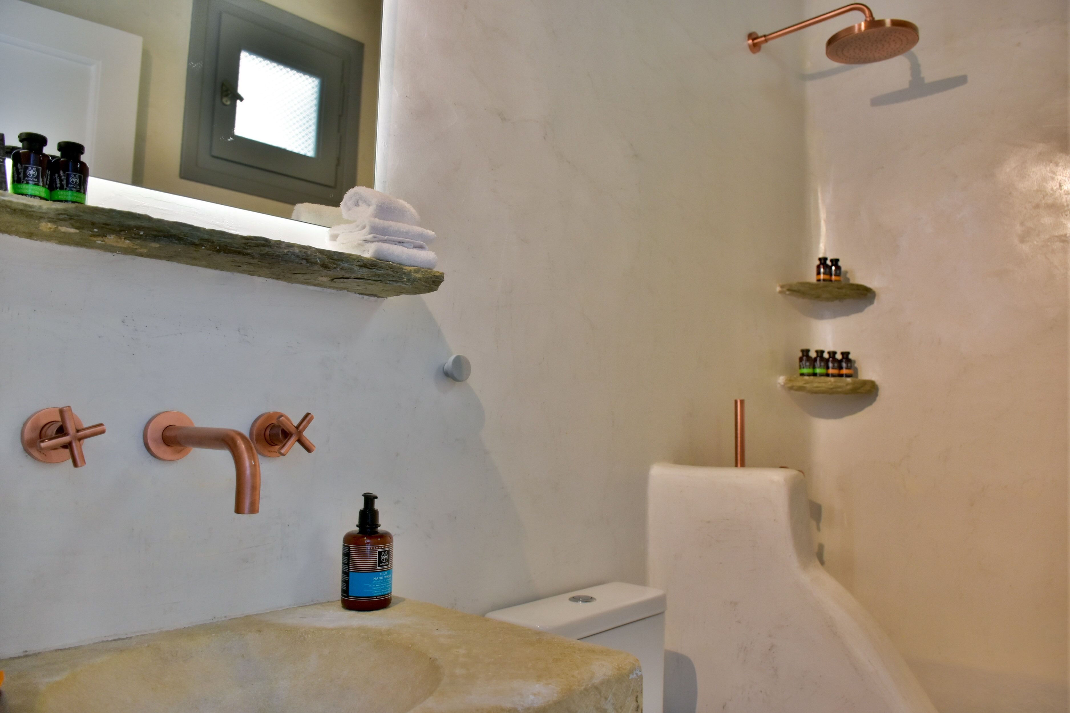 Un baño con lavamanos, dos llaves, inodoro y ducha.
