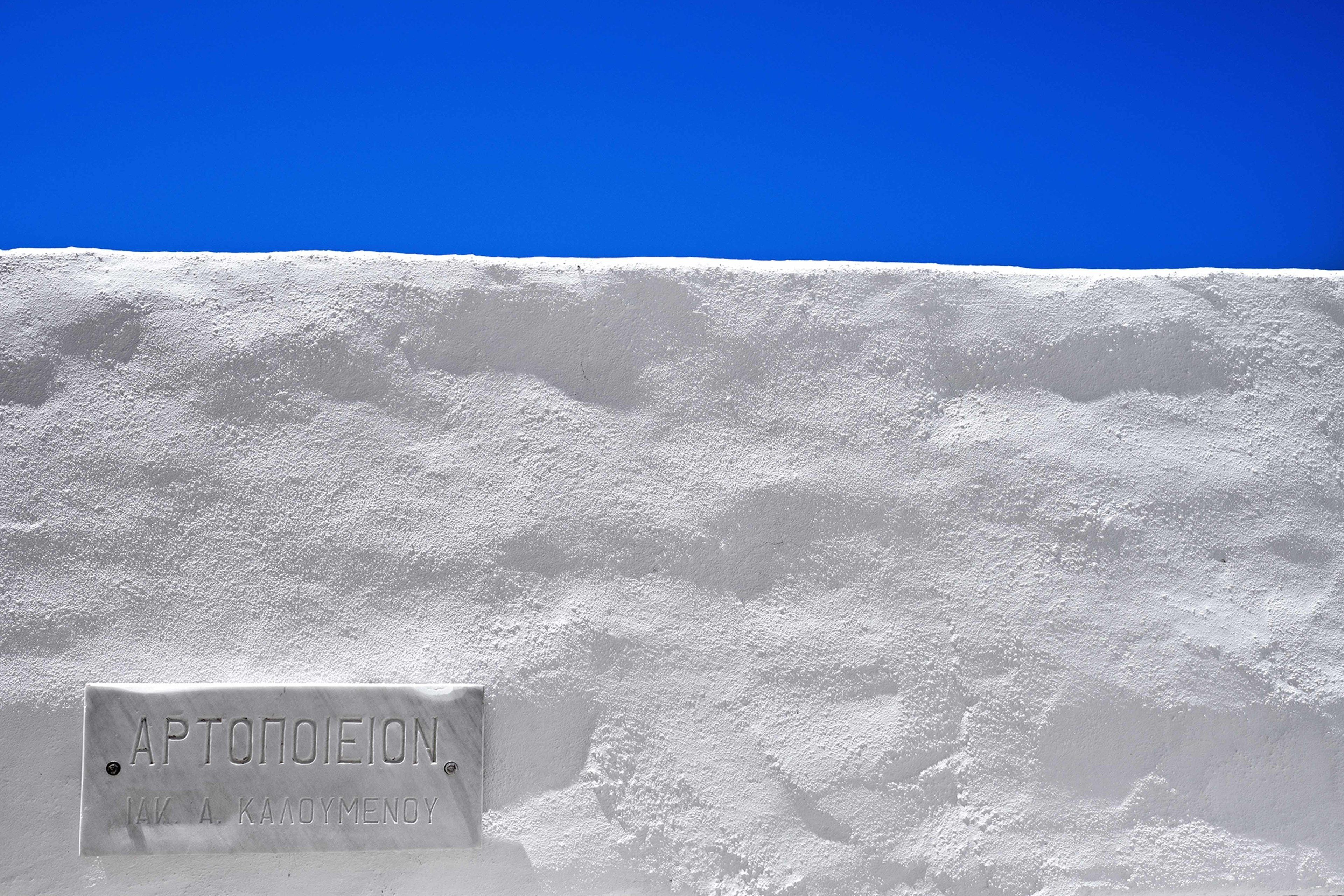 A sign on a snow-covered surface with the text "APTONOIEION" and "IAK A. KAAOYMENOY".