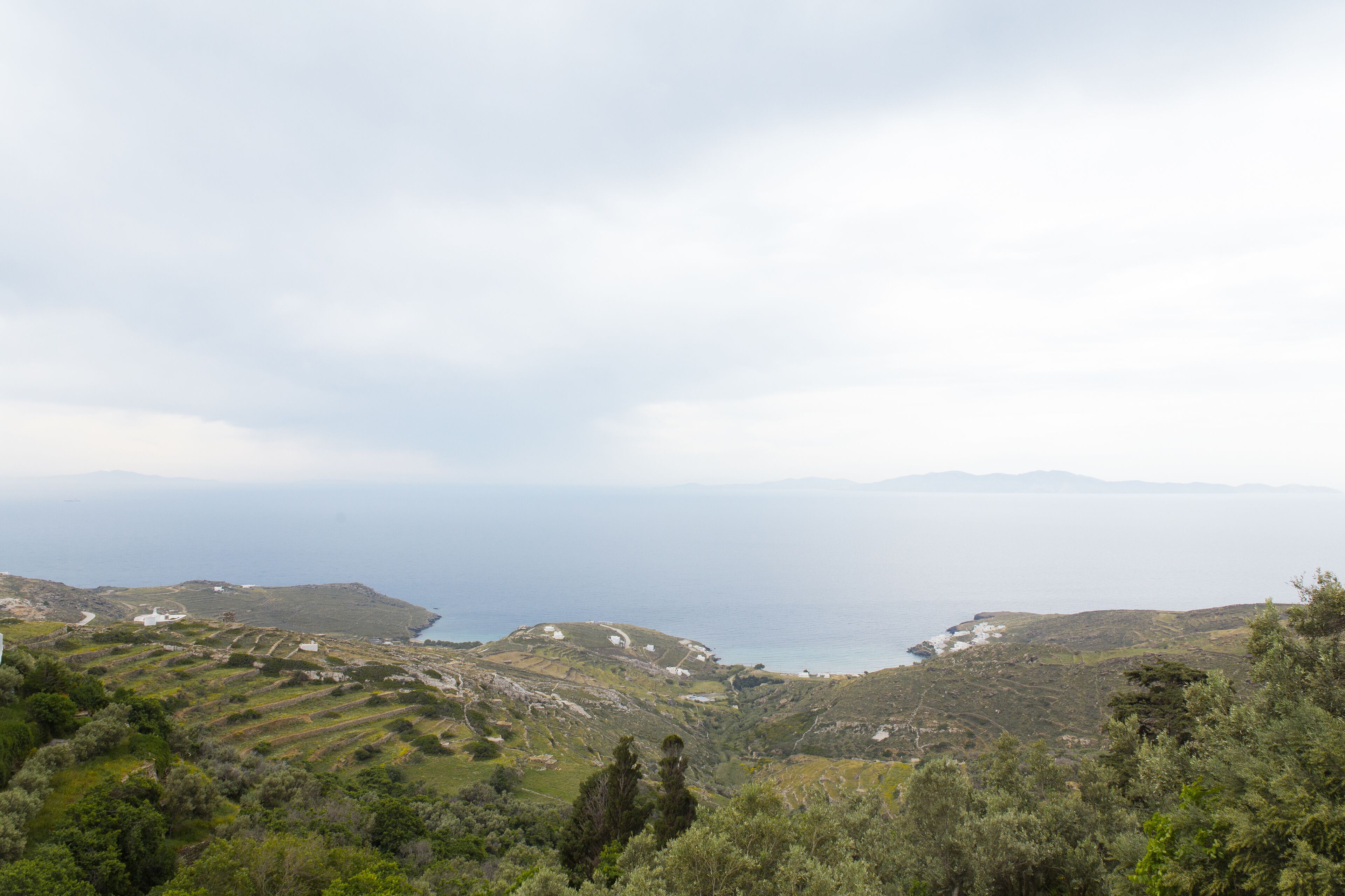 Un paisaje costero con campos escalonados y vistas al mar.