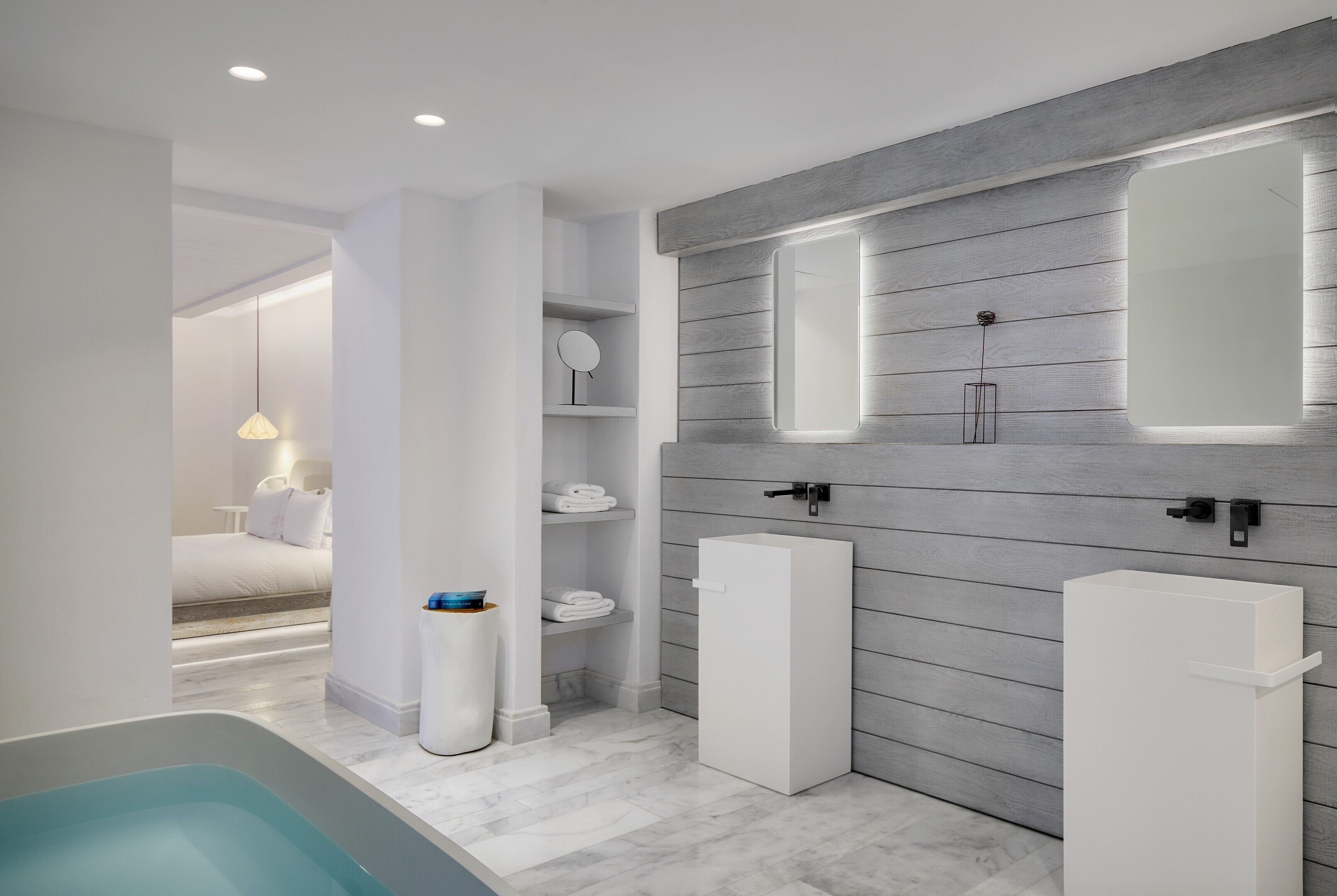 A modern bathroom with a bathtub, a sink, and a mirror.
