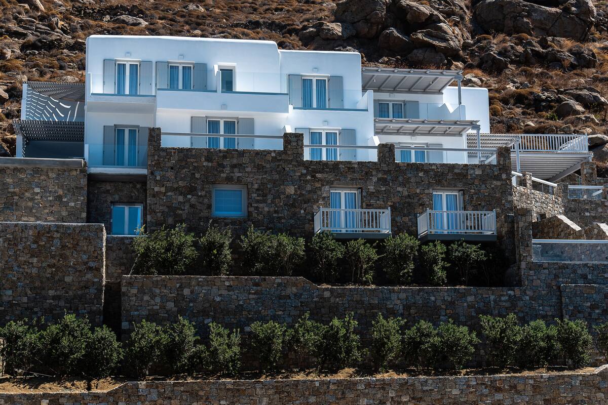 A modern building with multiple balconies and a stone facade.