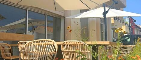 An outdoor seating area with wicker chairs and a large umbrella.