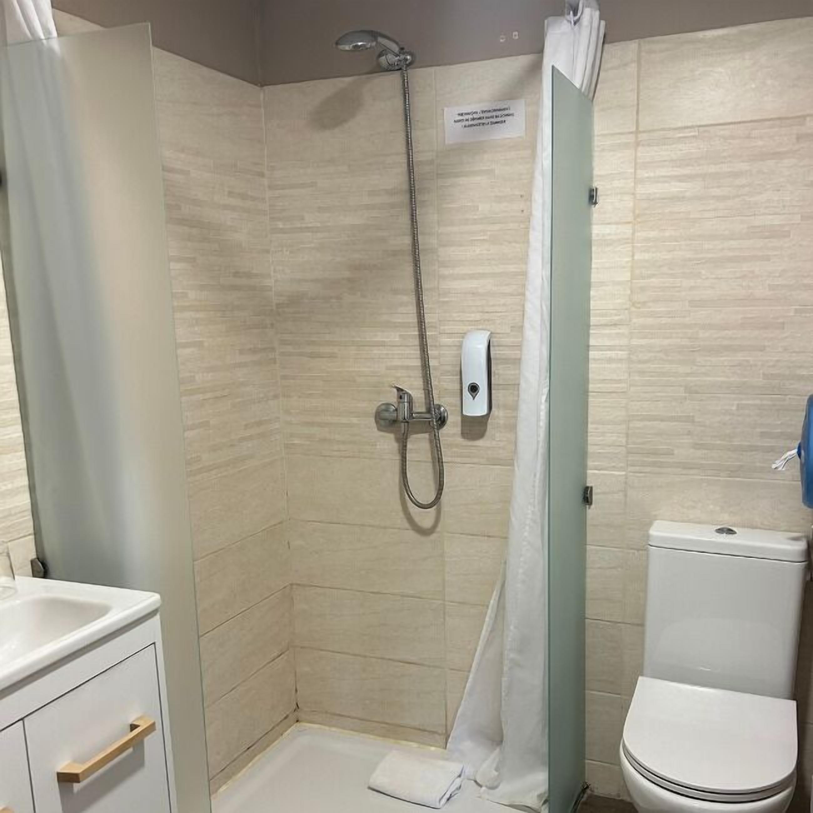 A bathroom with a shower, toilet, and a sink.