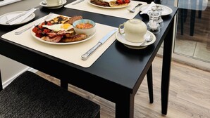 Une table à manger avec des assiettes pour le petit-déjeuner, une tasse et des couverts.