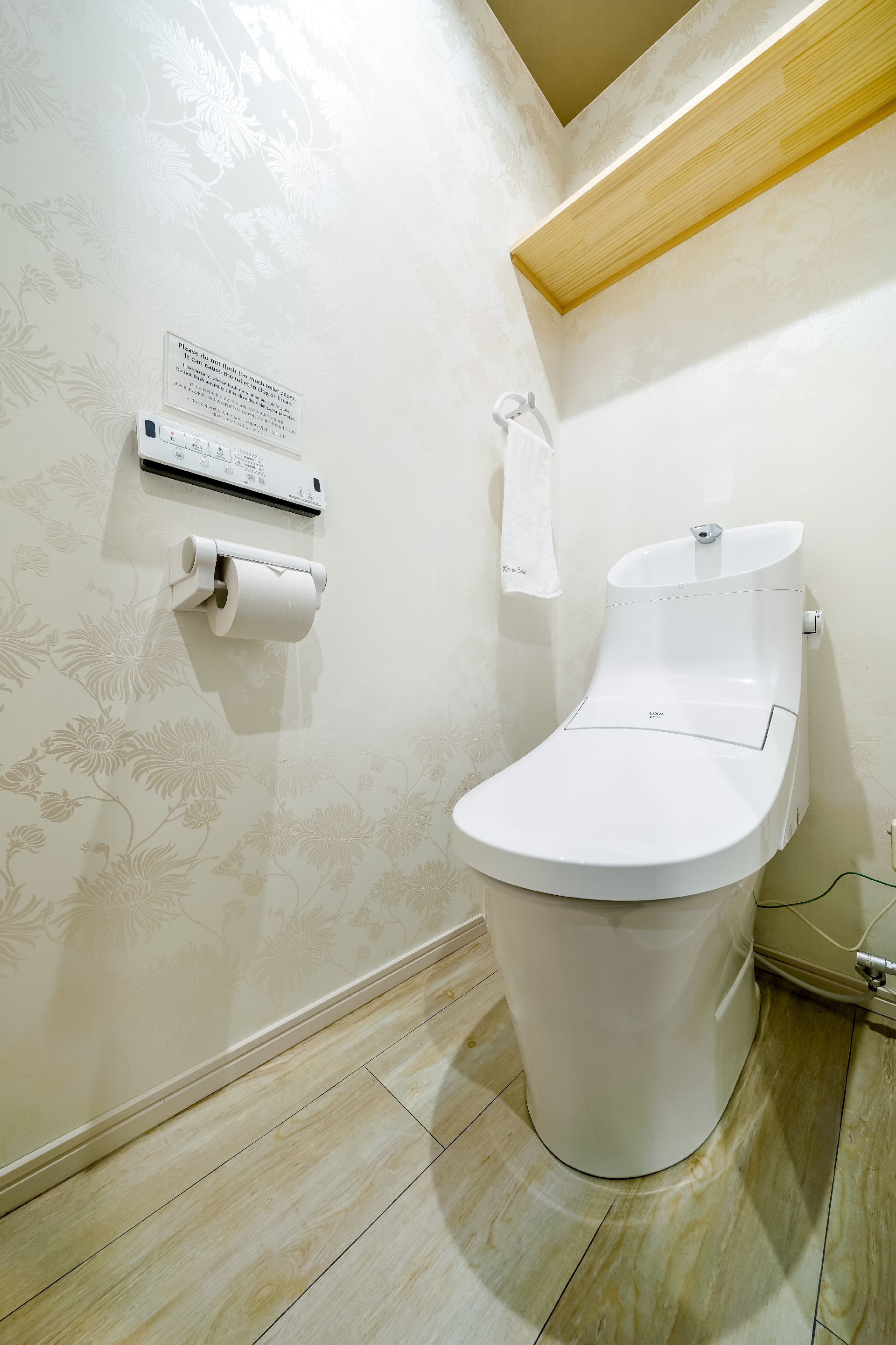 Une salle de bain moderne équipée de toilettes, d’un distributeur d’essuie-tout et d’un climatiseur fixé au mur.