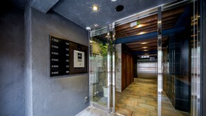 A modern elevator with a digital display and a glass door. - RESI STAY Tsubaki (Kyoto)