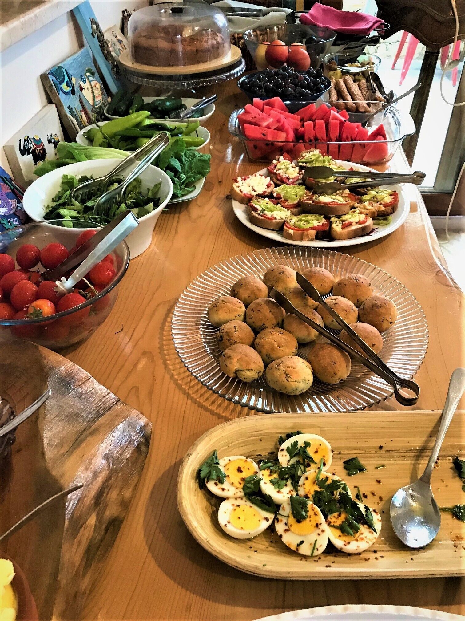A buffet table with various food items including salads, fruits, and appetizers.