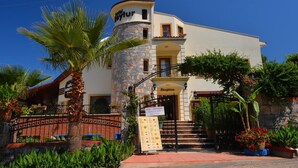 A hotel with a stone facade, a reception area, and a sign indicating non-resident guests are welcome.