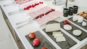 Noutopöytä, jossa on tarjolla erilaisia ruokia ja ruokailuvälineitä.