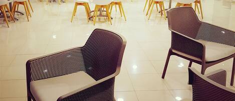A spacious indoor area with multiple tables and chairs arranged for dining or meetings.