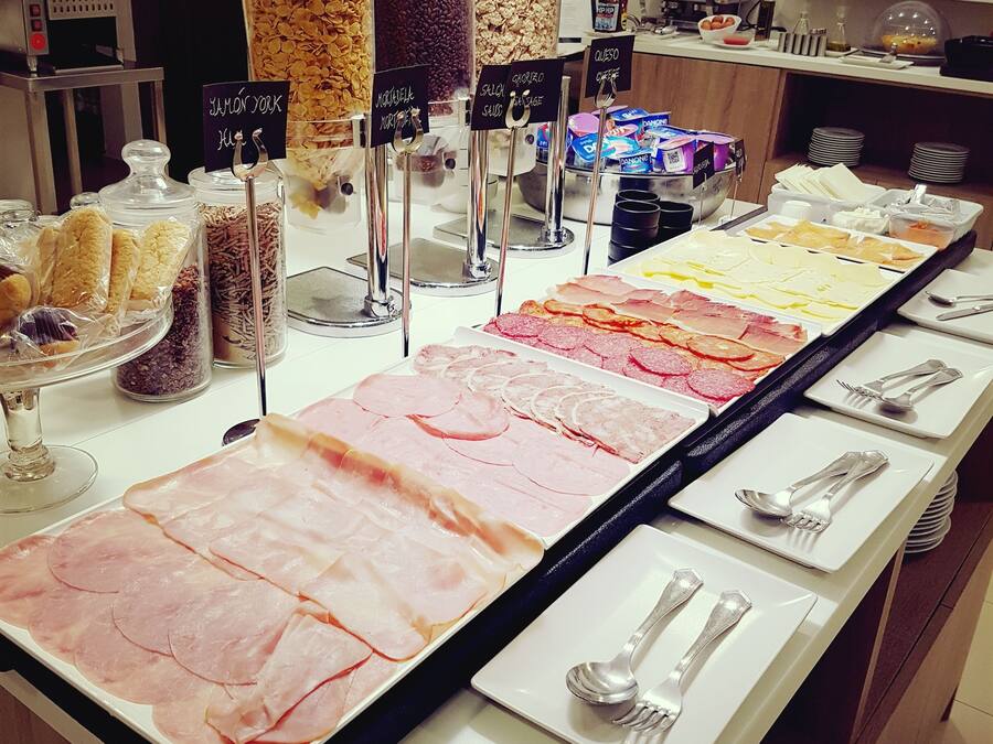 A buffet with various food items and utensils.