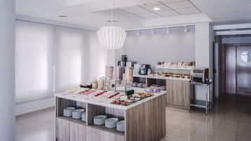 A modern kitchen with a central island, white cabinets, and a hanging light fixture.