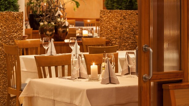 A dining area with tables set for two, featuring white tablecloths, candles, and glassware. - Hotel Tannerhof (Schenna)