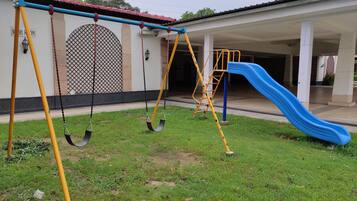 Guests can enjoy a fun outdoor play area with a swing set and slide.