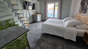 Een slaapkamer met een bed, een bureau en een trap.