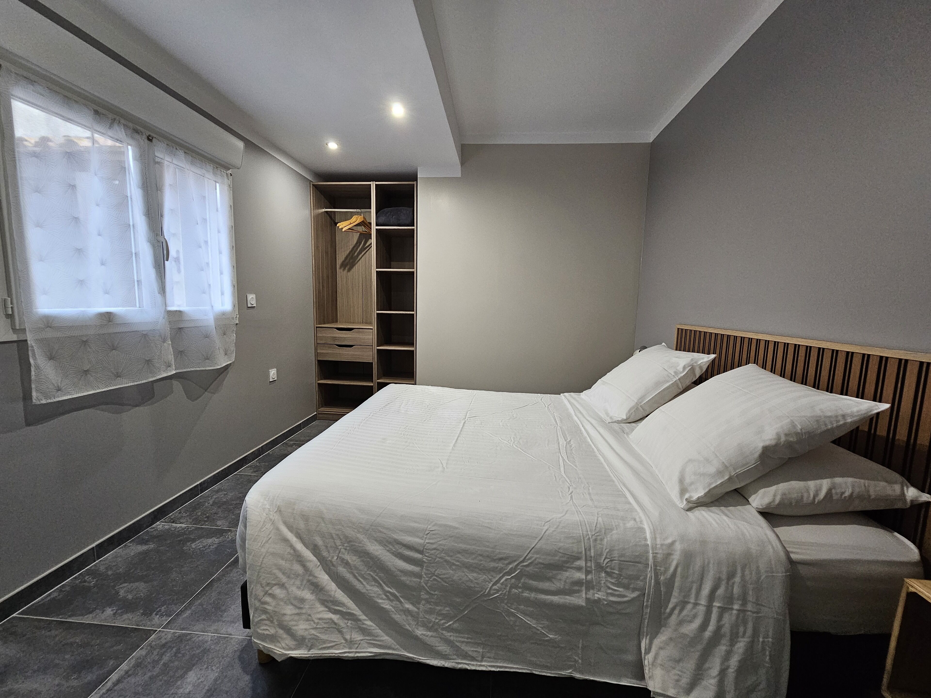 Une chambre à coucher comprenant un lit, une armoire et un dressing.