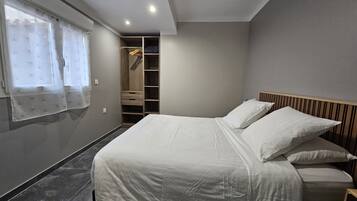Une chambre à coucher comprenant un lit, une armoire et un dressing.