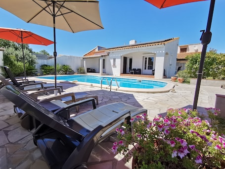 Una piscina al aire libre de temporada, sombrillas. La Casa del Arti