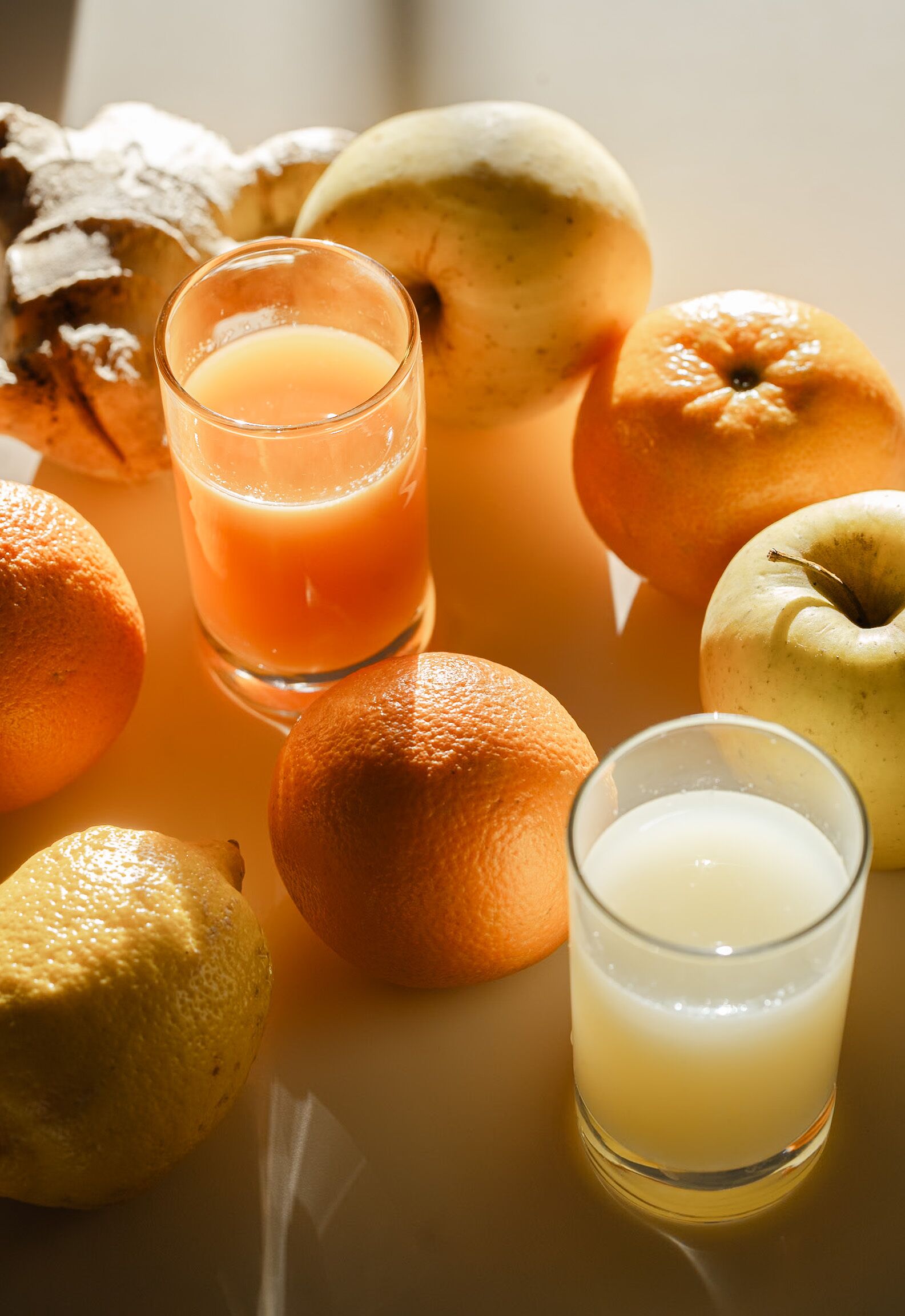 Une table avec différents fruits et des verres de jus.
