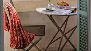 A balcony with a table, a chair, and a view of a marina and mountains. - Hotel du Golfe (Ajaccio)