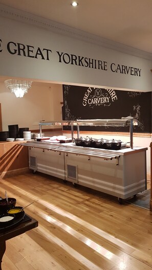 A buffet setup with a sign reading "GREAT YORKSHIRE CARVERY" and a chalkboard with the same name.