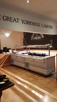 A buffet setup with a sign reading "GREAT YORKSHIRE CARVERY" and a chalkboard with the same name.