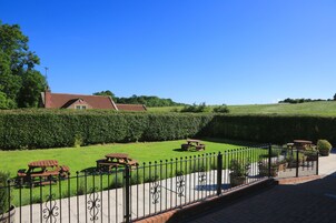 A well-maintained lawn with picnic tables and a fence.