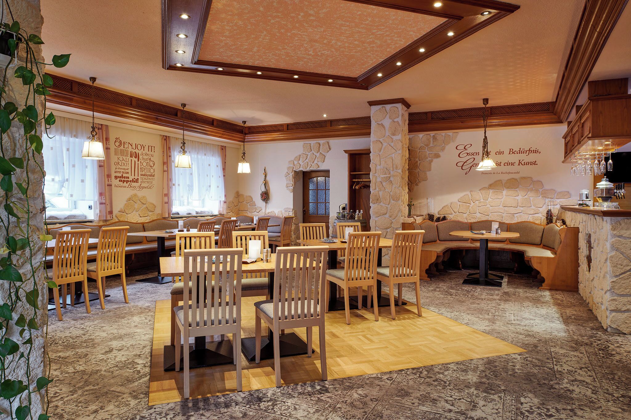 Un restaurante con muebles de madera, paredes de piedra y un ambiente acogedor.