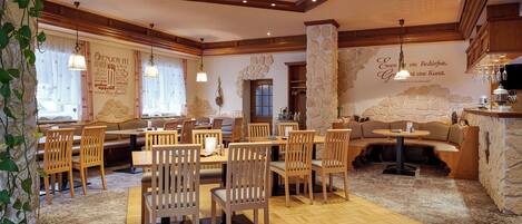 Un restaurante con muebles de madera, paredes de piedra y un ambiente acogedor.