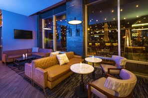A modern interior with a sofa, armchairs, a coffee table, and a TV mounted on the wall. - Hyatt Place Milwaukee/Downtown (Milwaukee)