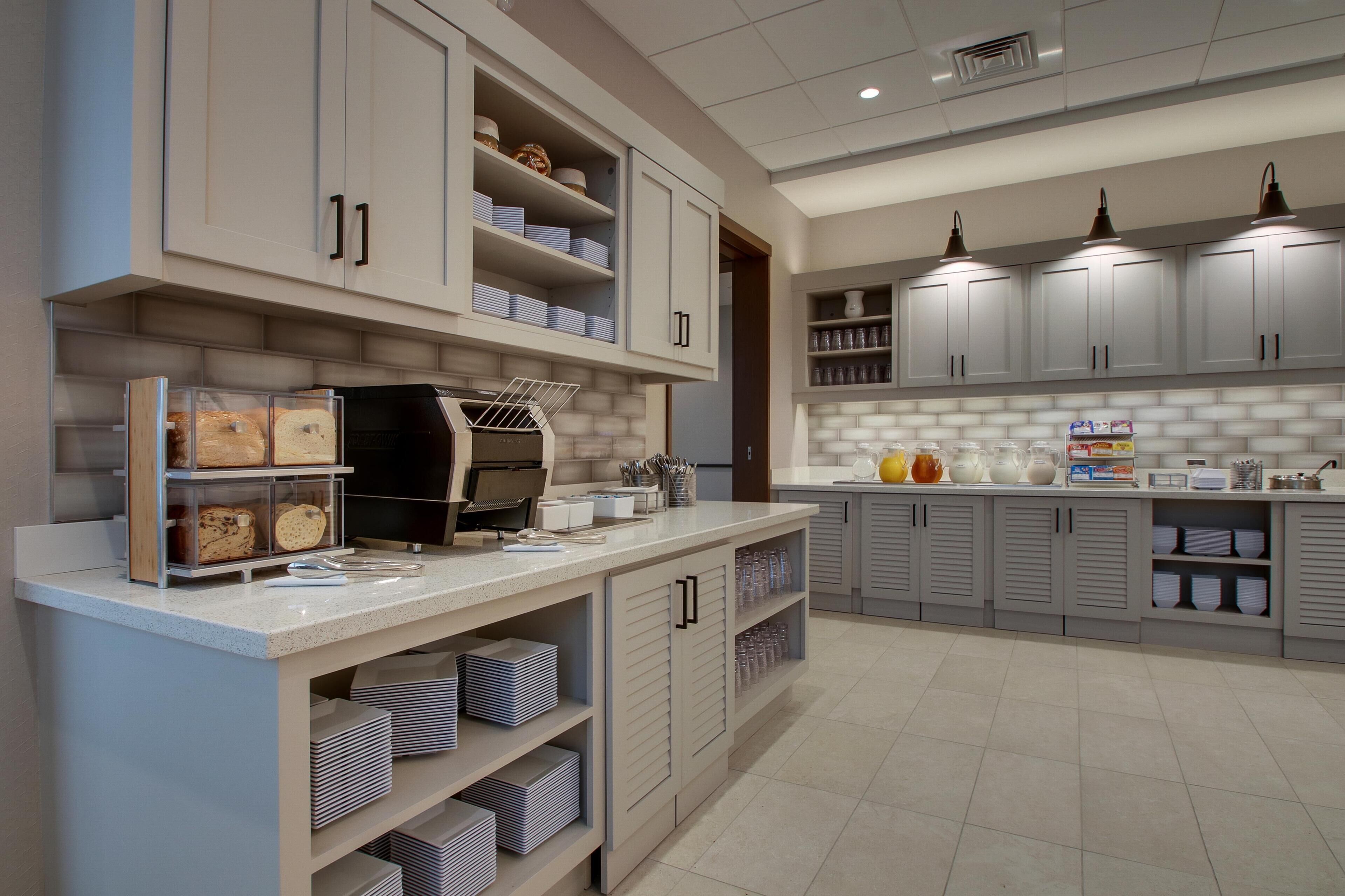 A modern kitchen with built-in cabinets, a central island, and a variety of appliances.
