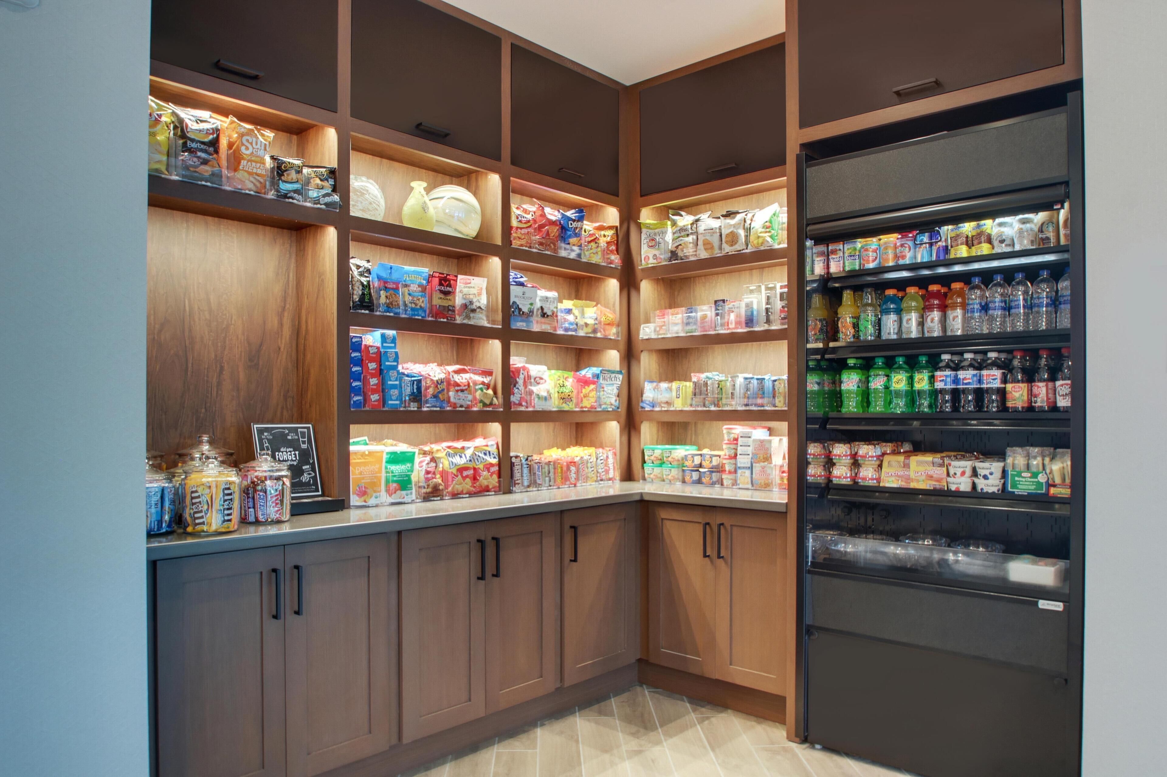 A well-organized pantry with shelves stocked with various food items and a refrigerator.