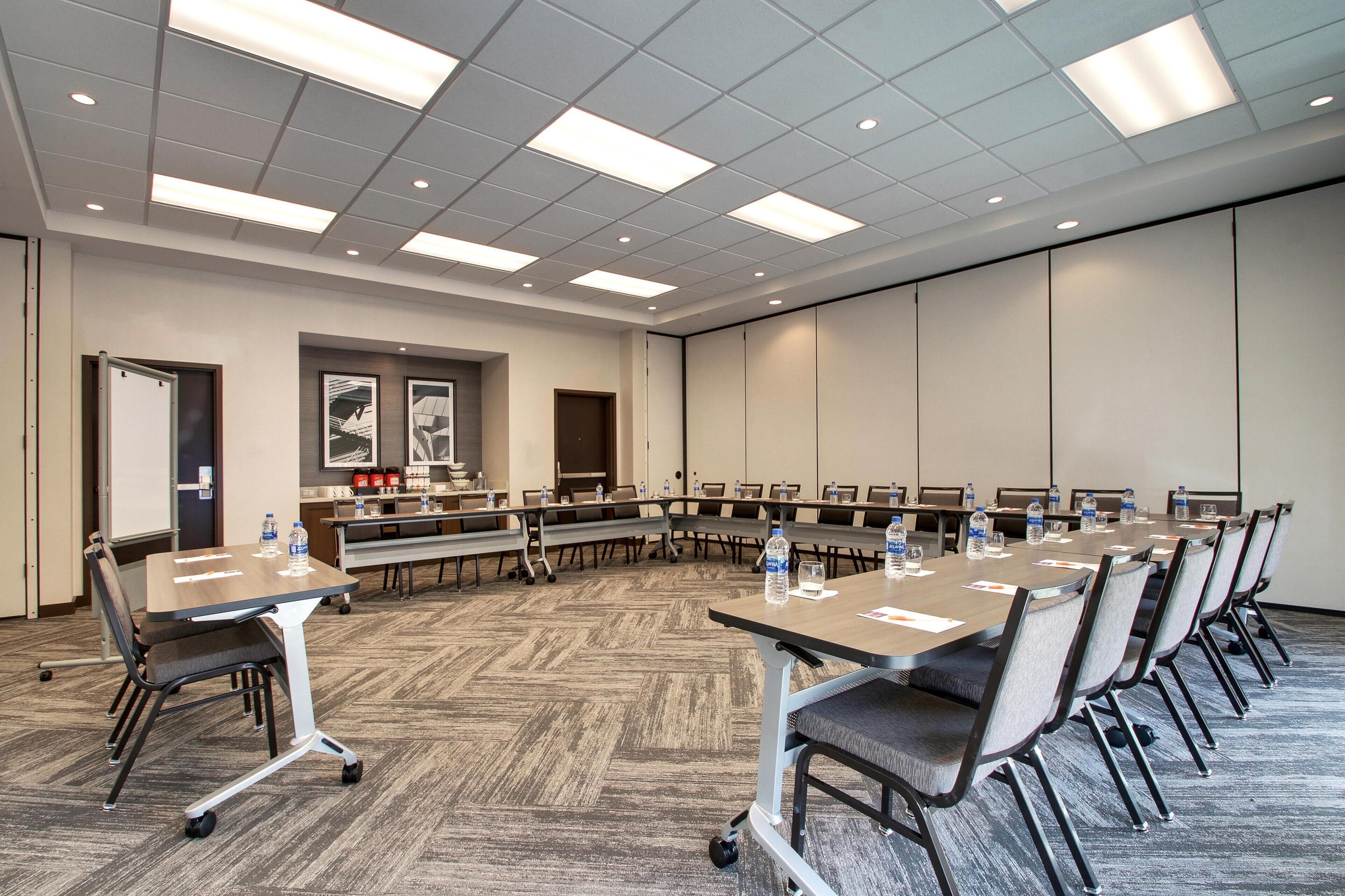 A conference room with a long table, chairs, and a whiteboard.