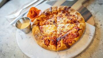 Une pizza sur une assiette, avec une fourchette et un couteau à côté.