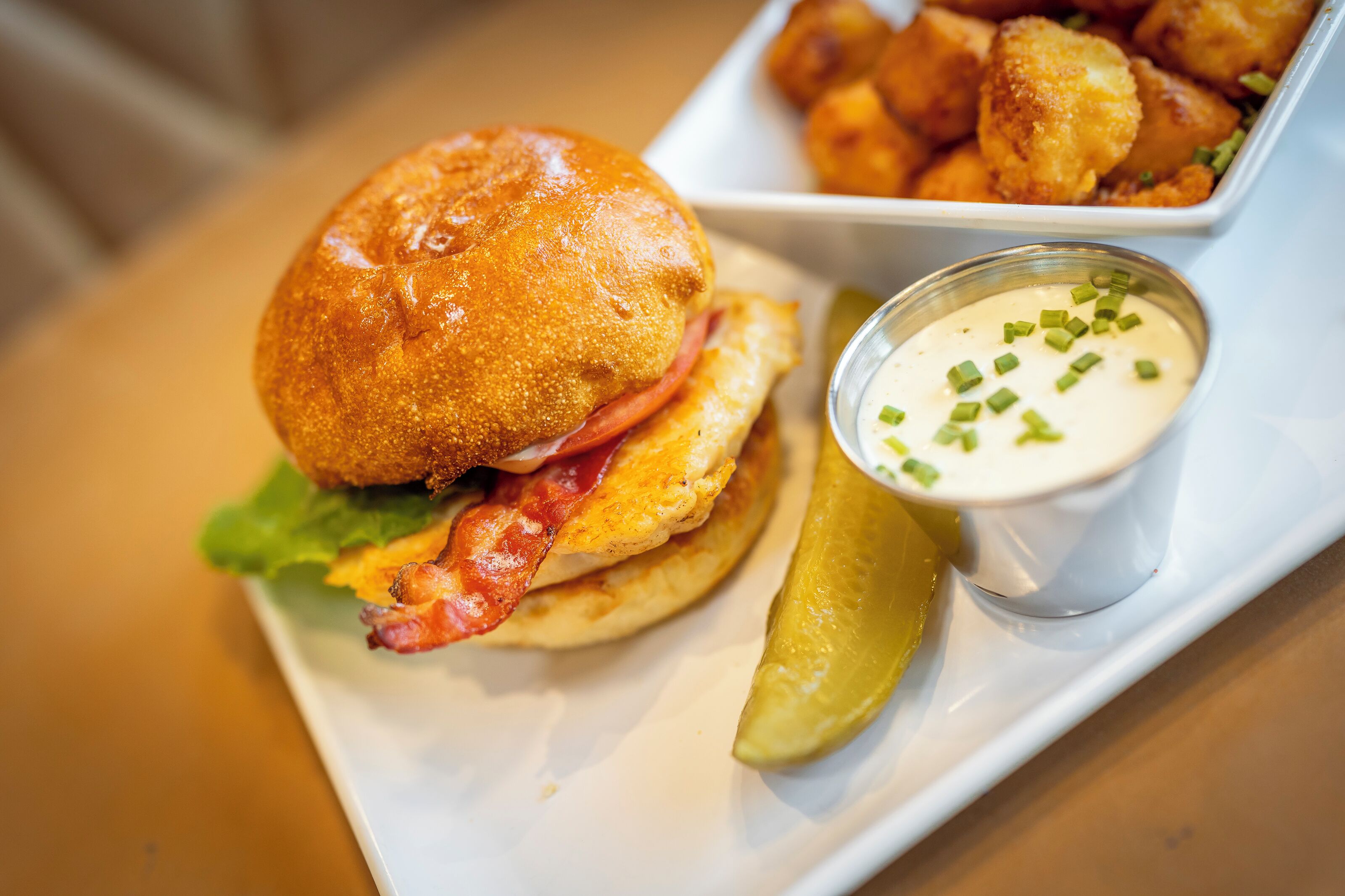 A plate with a burger, fries, and a side of sauce.