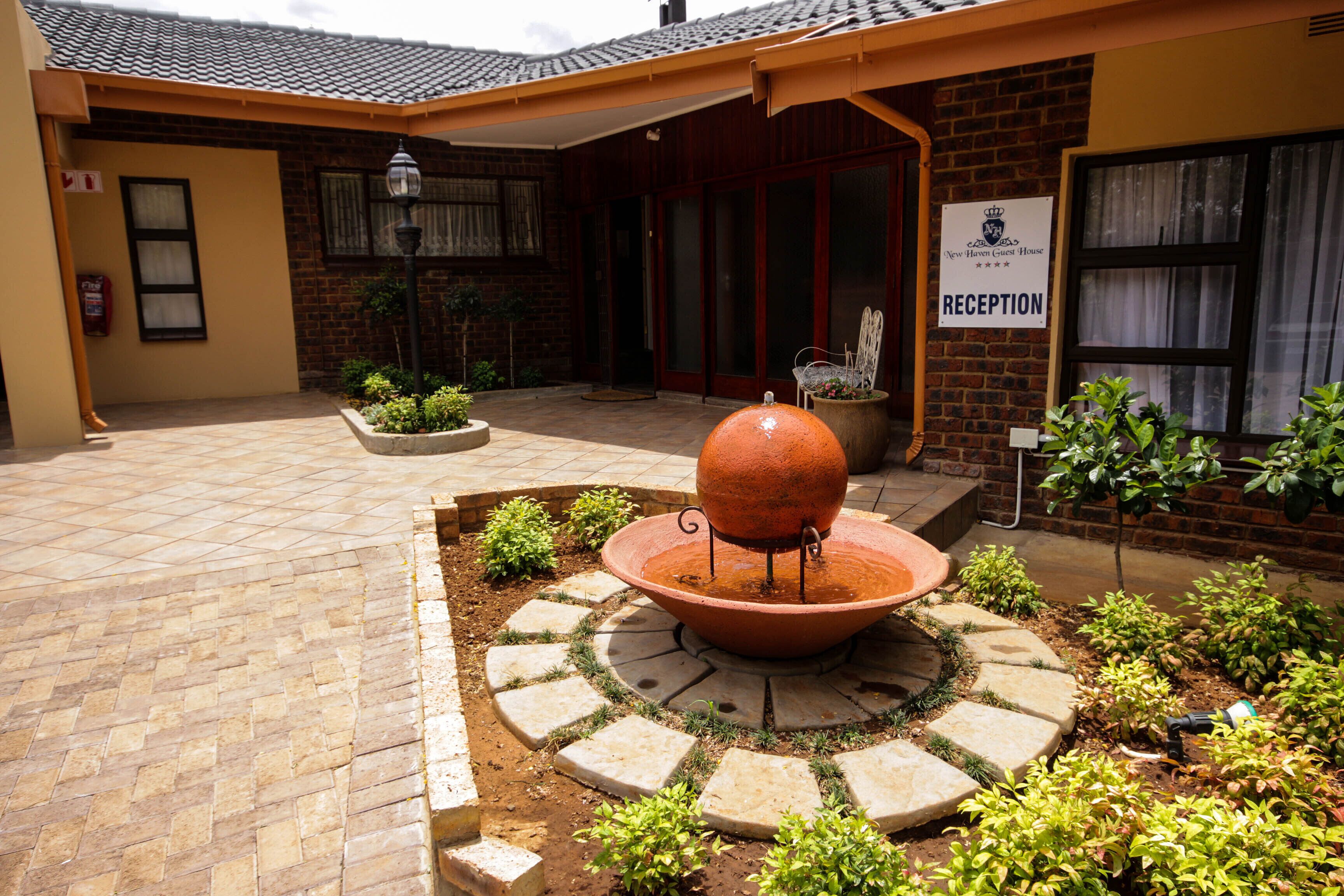 A reception area with a large planter, a chair, and a sign indicating the reception.