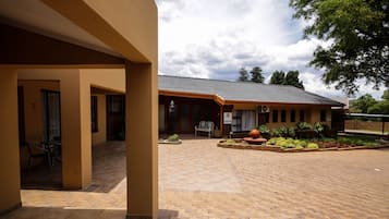 A building with a tiled patio, a reception desk, and a bench.